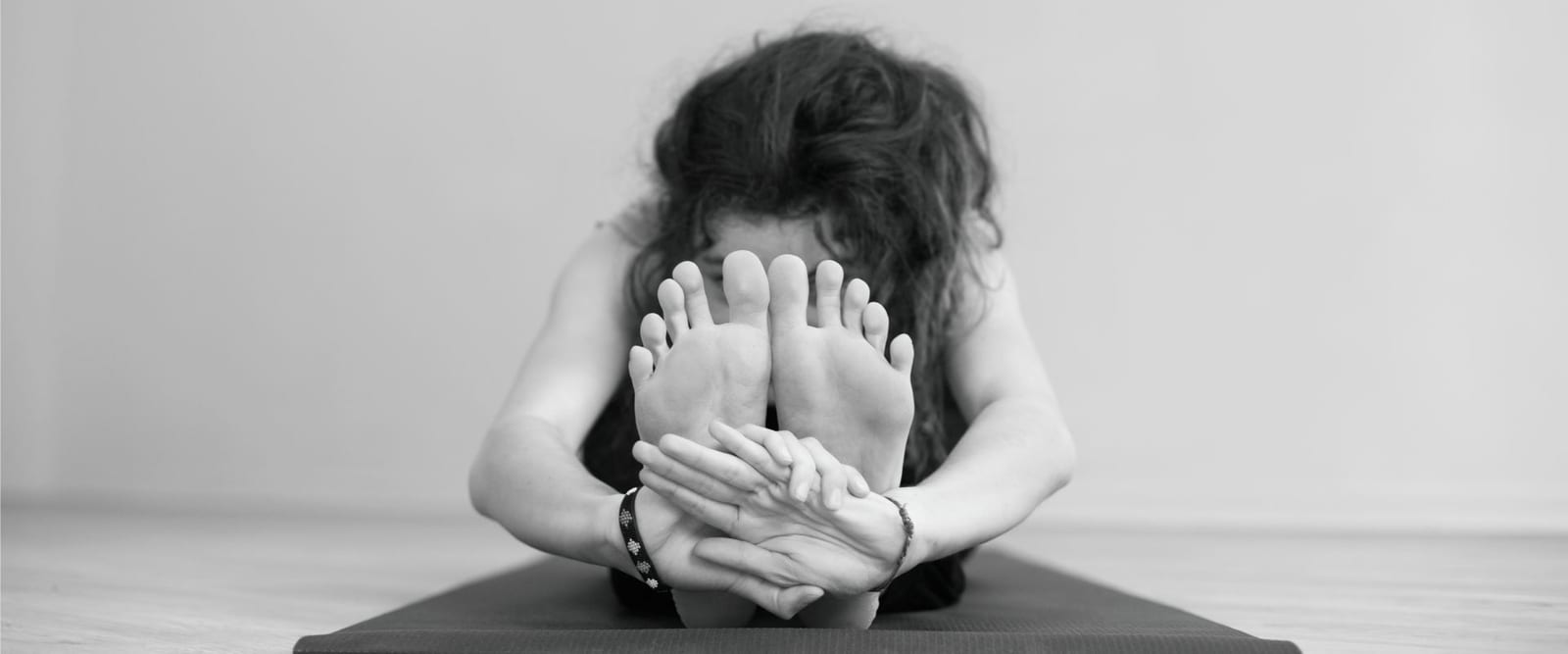 Frau in einer Vorwärtsbeuge auf der Matte im athayoga Studio Wuppertal