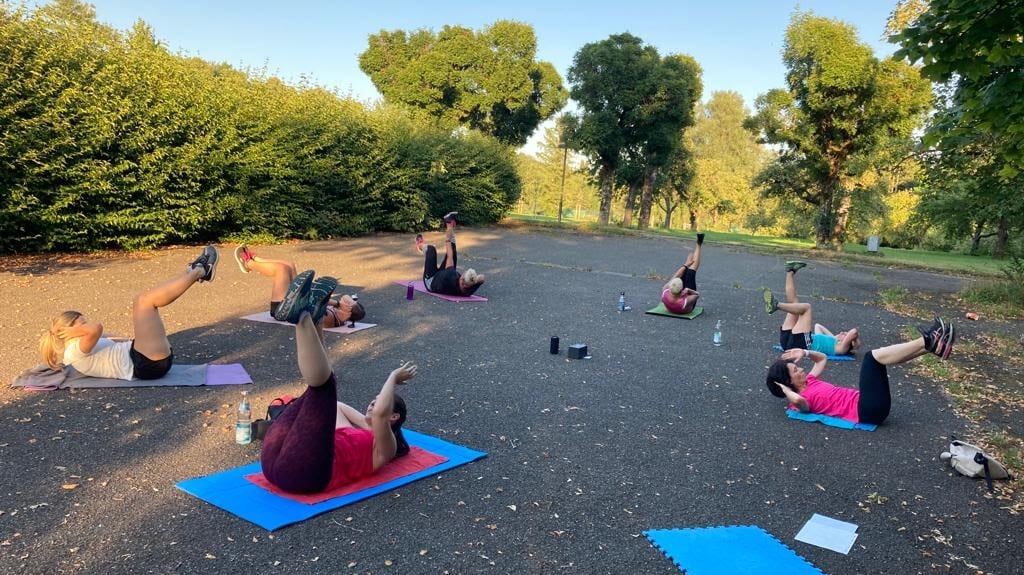 Gruppe von burpee & run beim Outdoor-Circuit-Training auf einem Platz in Bad Waldsee im Abendlicht