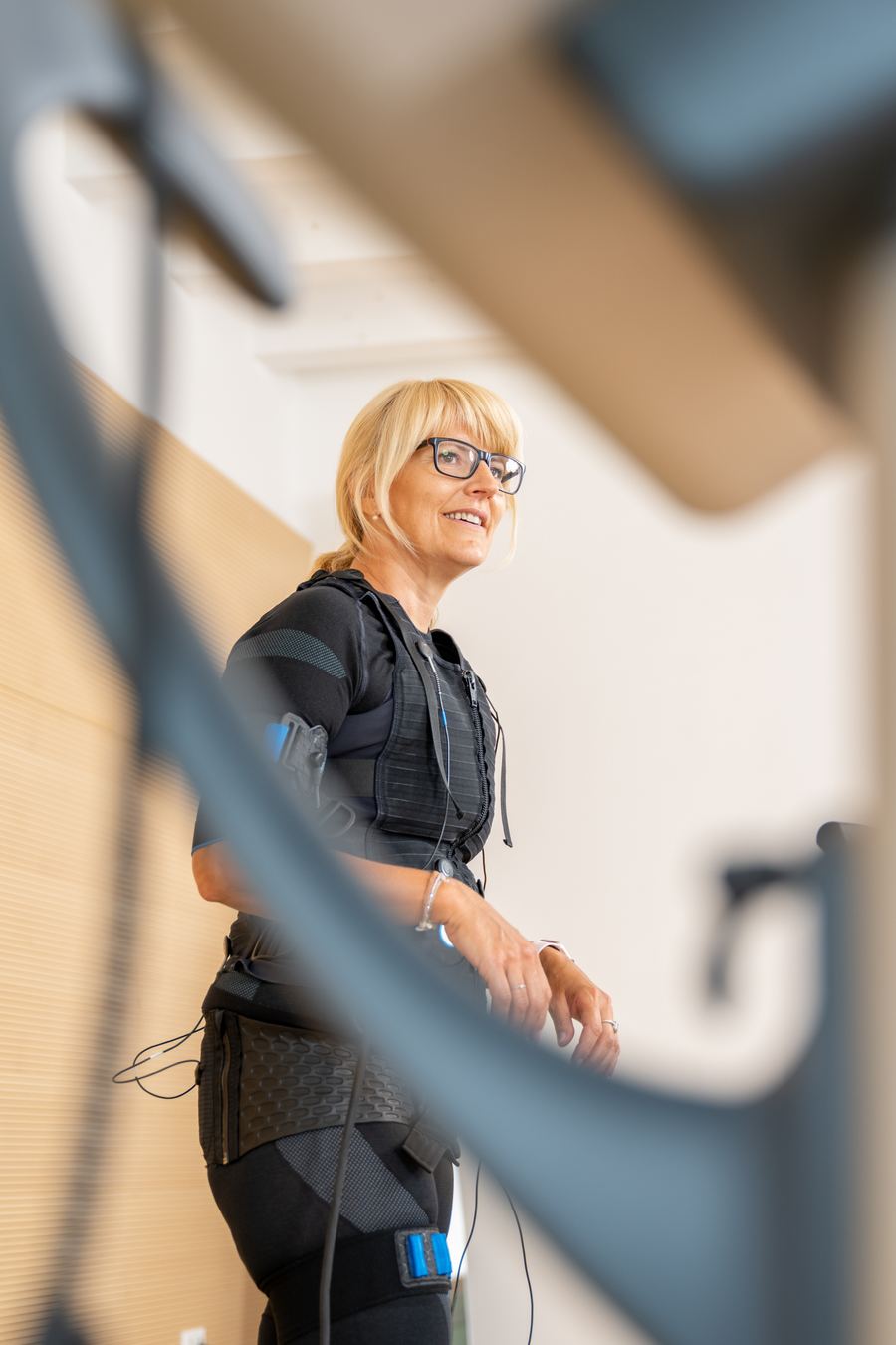 Julia Codet lächelnd im EMS-Anzug in ihrem Studio in Hollabrunn