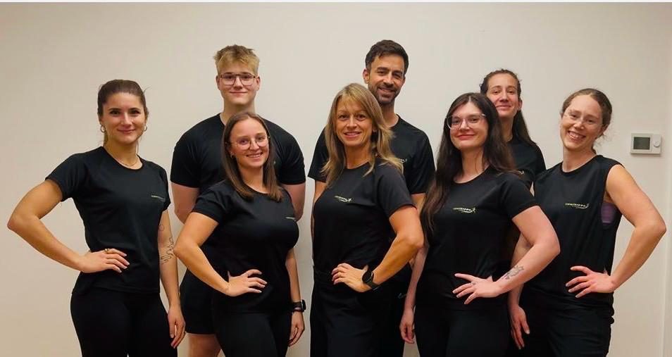Das achtköpfige Codetraining-Team in schwarzen Trainingsshirts