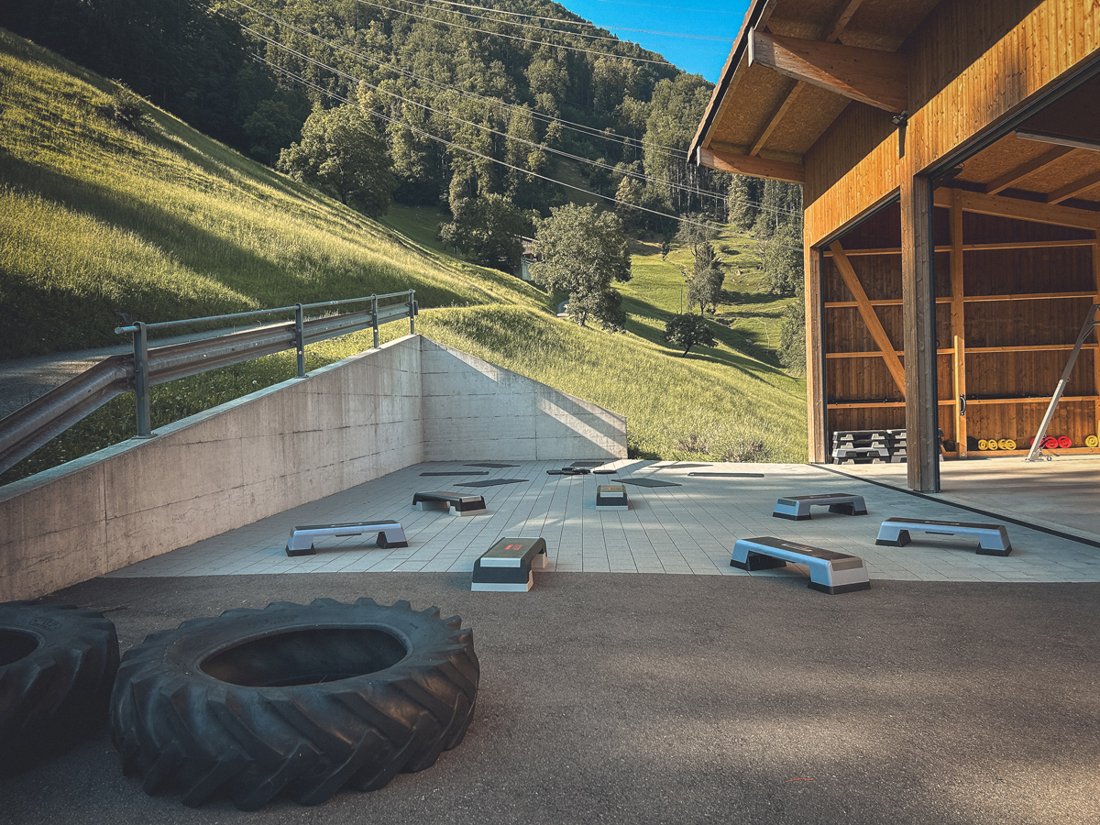 Innenraum der Remise von dra bliibe mit Trainingsgeräten und Bergblick