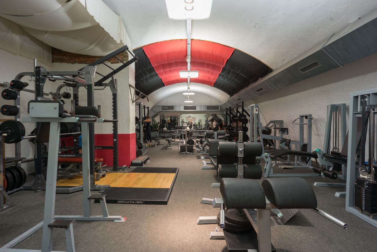 Freihantelbereich der Fitnesslounge Erlangen mit Racks und Plattform unter dem Gewölbesegel