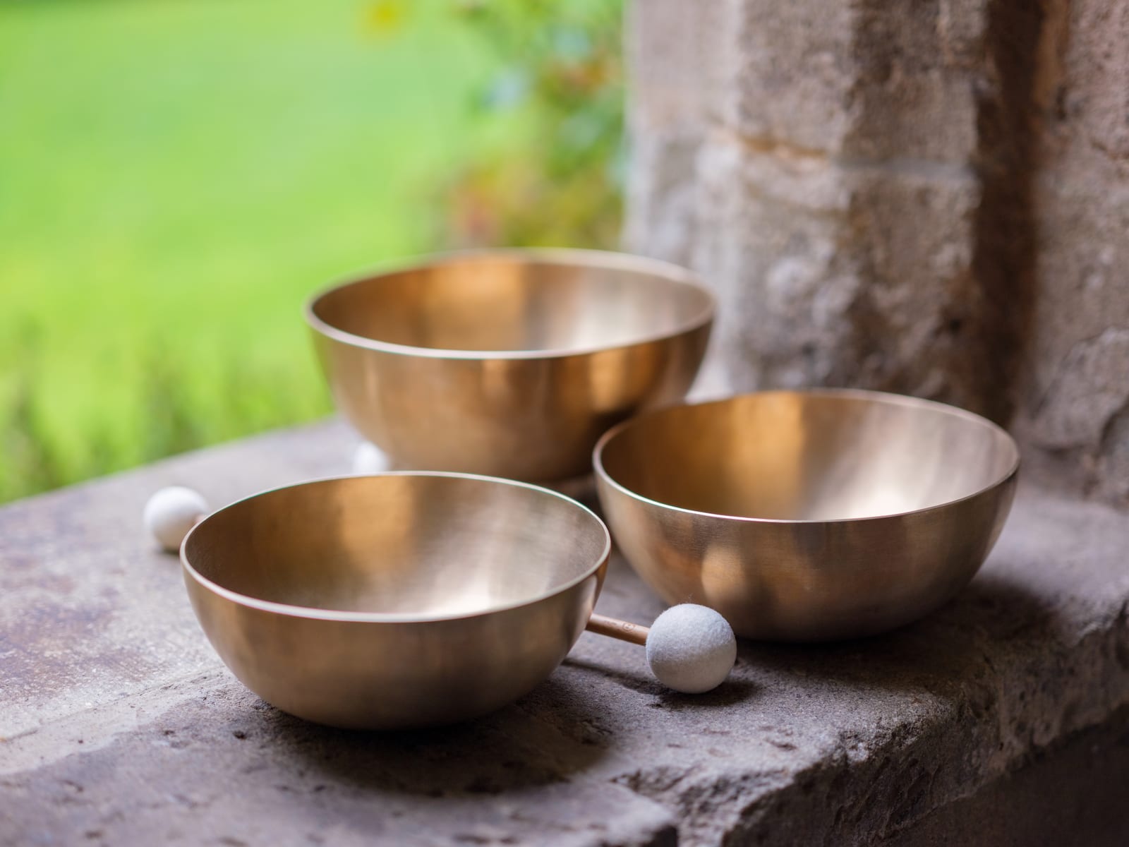 Klangschalen mit Schlägel auf alter Steinfensterbank