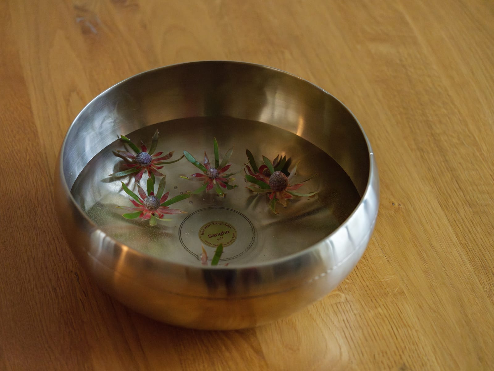 Klangschale mit Wasser und schwimmenden Blüten