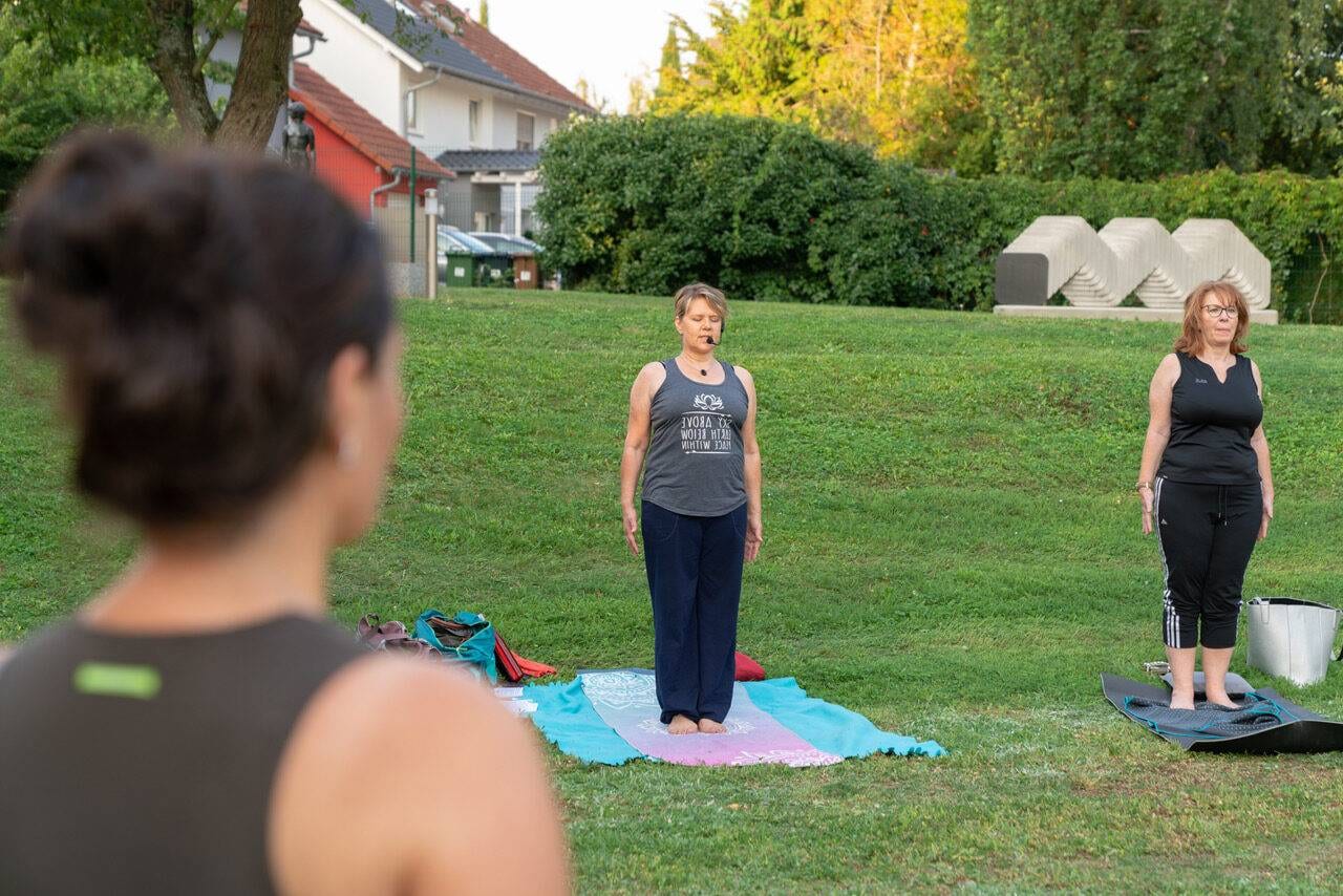 Manuela Förg unterrichtet eine kleine Gruppe im Freien auf einer Wiese im Skulpturenpark