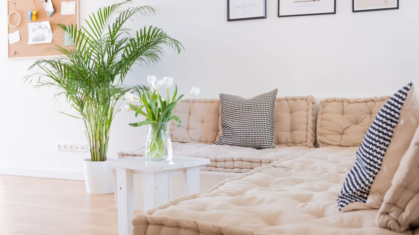 Gemütliche Sitzecke mit Kissen und weißen Tulpen im Yogastudio
