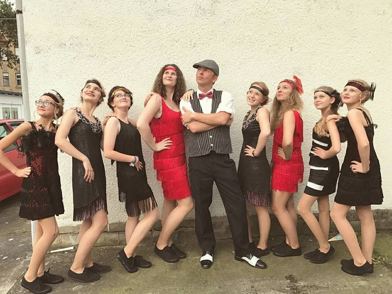 Showgruppe in 20er-Jahre-Kostümen mit Miles Shane in der Mitte