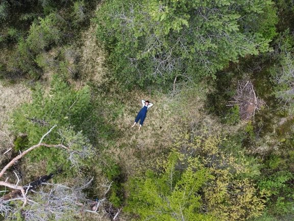 Silvia liegt entspannt in einer Waldlichtung — Drohnenaufnahme von oben