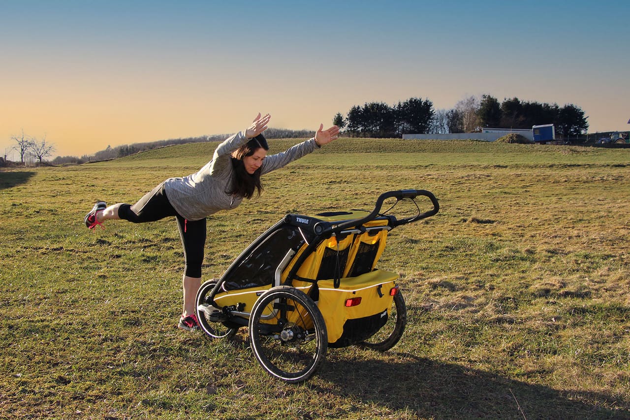 Johanna Roth in einer Standwaage auf einer Wiese im Abendlicht, daneben ihr Kinder-Laufwagen