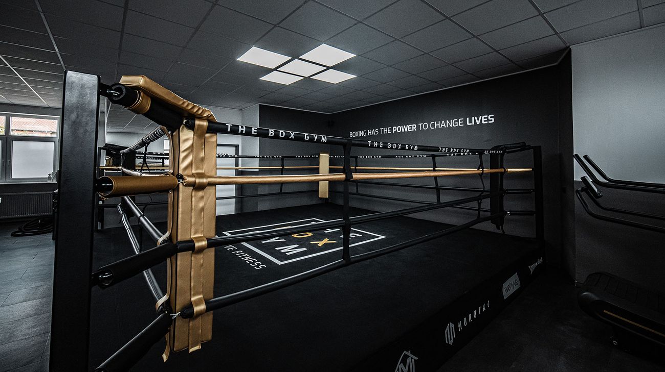 Boxring im THE BOX GYM mit goldenen Seilen und dem Schriftzug Boxing has the power to change lives