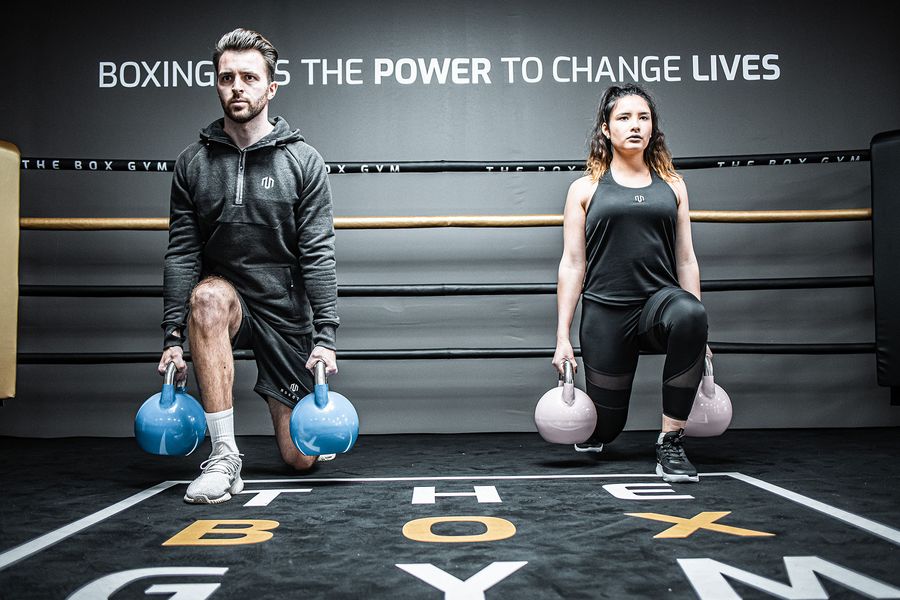 Zwei Trainierende mit Kettlebells im Ring von THE BOX GYM