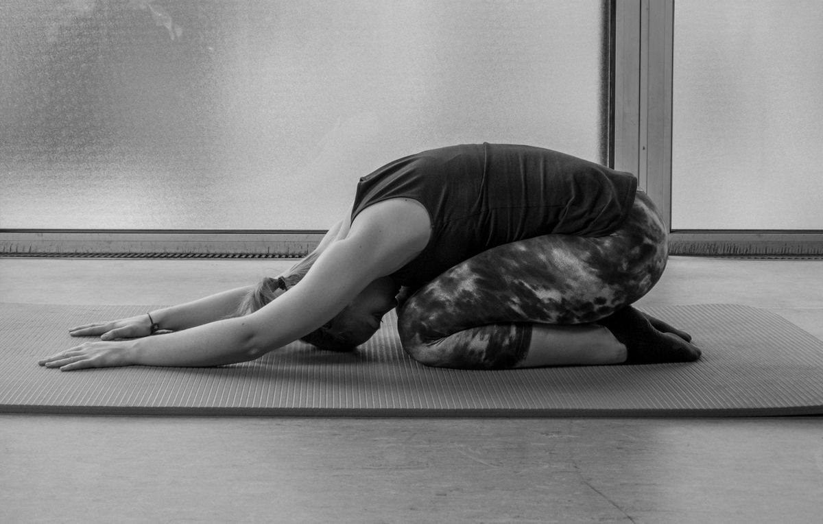 Sabrina Gründler in einer Dehnübung auf der Matte, Schwarzweiß-Aufnahme