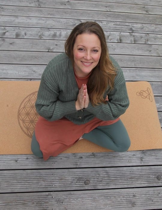 Manja Wulff-Kraeft im Schneidersitz auf ihrer Yogamatte